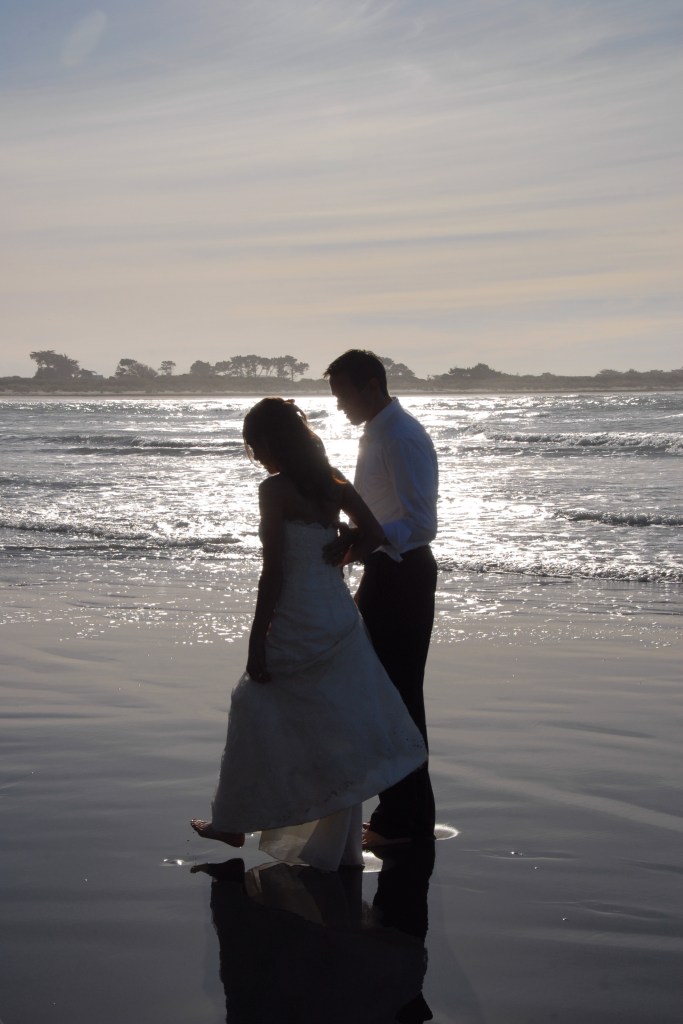 Couple walking together along the shoreline after their intimate New Zealand elopement